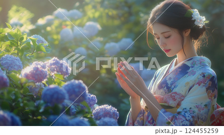 紫陽花の前でお辞儀をする着物女性 紫陽花の前でお辞儀をする着物女性 124455259