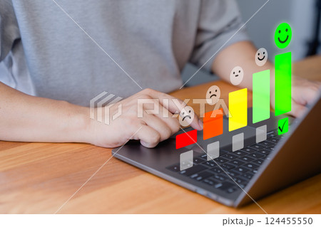 Customer using a laptop select a happy face icon from a feedback scale with five emoji option, symbolizing customer satisfaction, review, and positive user experience in an online feedback system. Customer using a laptop select a happy face icon from a feedback scale with five emoji option, symbolizing customer satisfaction, review, and positive user experience in an online feedback system. 124455550