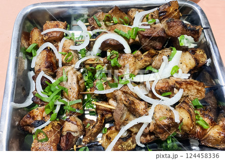 bbq pork shashlik with onions on a metal tray 124458336