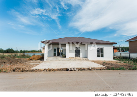 New house under construction on suburban street with blue sky background. Real estate development, investment, and residential planning 124458465