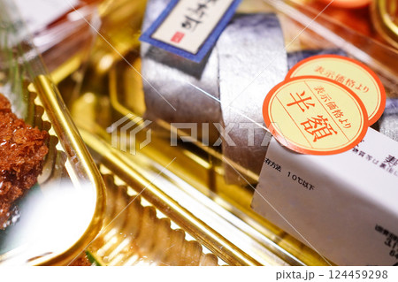 半額の値引きシールが貼られた夕方時のスーパーマーケットの寿司パック 124459298