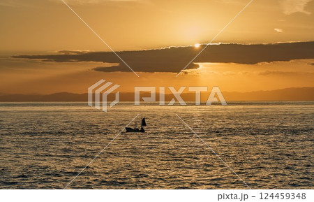 海に沈む夕日と漁船のシルエット ― 静けさと旅情を感じる夕景 124459348