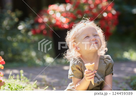 Happy curly-haired kid with ice cream on a sunny summer day. Happy curly-haired kid with ice cream on a sunny summer day. 124459389
