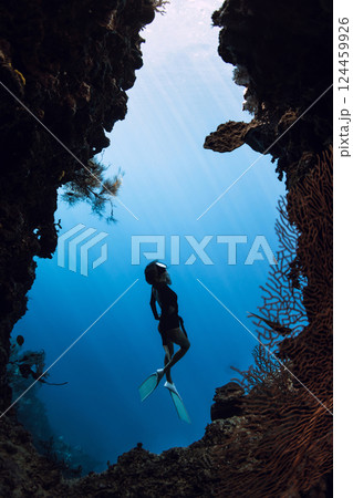 Woman dives in underwater cave on Menjangan island, Bali. Freediver swims in cave 124459926