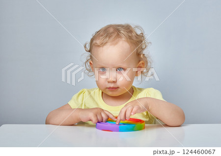 Popular Anti stress toy Pop It. Child Playing With The Pop It Fidget Toy. Happy childhood, popular educational games. 124460067