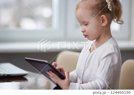 A girl is playing with a tablet. Copy space A girl is playing with a tablet. Copy space 124460190