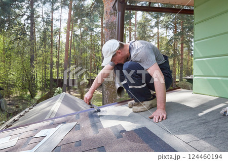A worker greases the roof of the terrace with mastic. A worker greases the roof of the terrace with mastic. 124460194