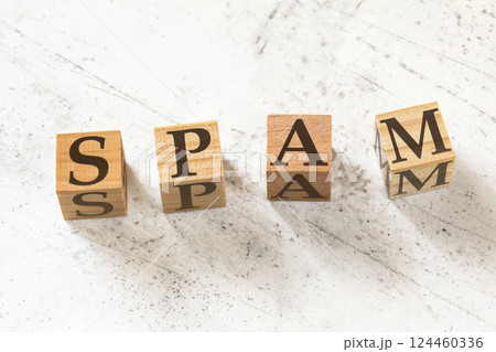 Four wooden cubes with word SPAM on white working board. 124460336