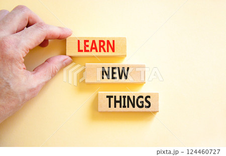 Learn new things symbol. Concept words Learn new things on beautiful wooden blocks. Beautiful white background. Businessman hand. Business motivational learn new things concept. Copy space. 124460727