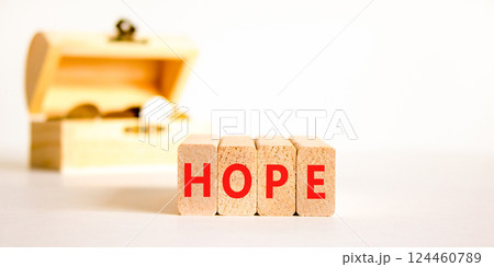 Hope symbol. Concept word Hope on beautiful wooden blocks. Beautiful wooden chest with coins. Beautiful white table white background. Business, lifestyle, support and hope concept. Copy space. Hope symbol. Concept word Hope on beautiful wooden blocks. Beautiful wooden chest with coins. Beautiful white table white background. Business, lifestyle, support and hope concept. Copy space. 124460789