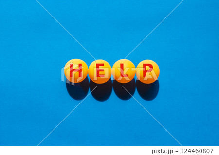 Help symbol. Concept word Help on beautiful yellow ping pong balls. Beautiful blue table blue background. Business, lifestyle, support and help concept. Copy space. 124460807