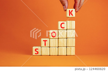 Stock symbol. Concept word Stock on beautiful wooden blocks. Beautiful orange table orange background. Businessman hand. Business lifestyle stock concept. Copy space. Stock symbol. Concept word Stock on beautiful wooden blocks. Beautiful orange table orange background. Businessman hand. Business lifestyle stock concept. Copy space. 124460820
