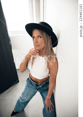 Model posing in casual outfit with hat in indoor setting 124461181