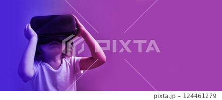Metaverse Technology concepts. hild in VR glasses in neon light. Banner colorful background with copy space. Metaverse Technology concepts. hild in VR glasses in neon light. Banner colorful background with copy space. 124461279