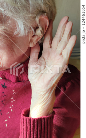 Middle age woman smiling confident using hearing aid Middle age woman smiling confident using hearing aid 124461654