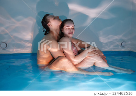 A couple in love enjoys relaxation in a pool with concentrated sea water. Floating for two 124462516