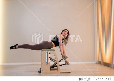 Asian woman doing pilates classic chair.  124462631