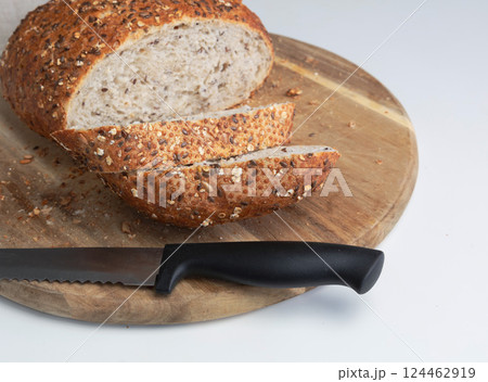 Round freshly oat baked bread sliced on a cutting board. Round freshly oat baked bread sliced on a cutting board. 124462919