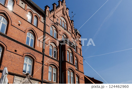 An ancient red brick building on a sunny day against a blue sky. 124462960