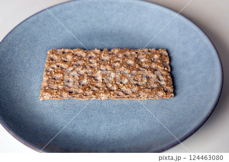 One piece of crunchy crispbread on a plate One piece of crunchy crispbread on a plate 124463080
