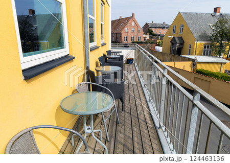 A large veranda or balcony with chairs and tables for relaxing on a summer day. A large veranda or balcony with chairs and tables for relaxing on a summer day. 124463136