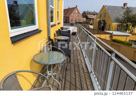A large veranda or balcony with chairs and tables for relaxing on a summer day. A large veranda or balcony with chairs and tables for relaxing on a summer day. 124463137