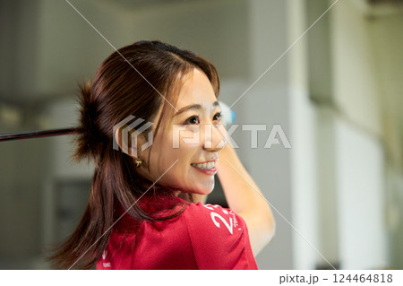 室内ゴルフ練習場で練習をする女性 124464818