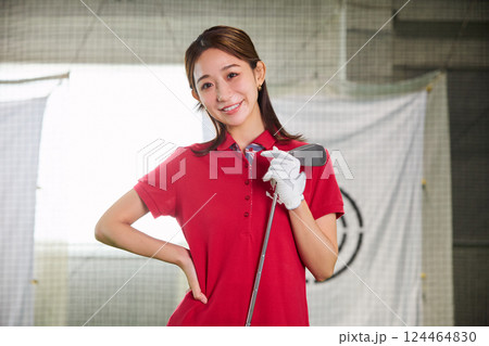 室内ゴルフ練習場で練習をする女性 124464830