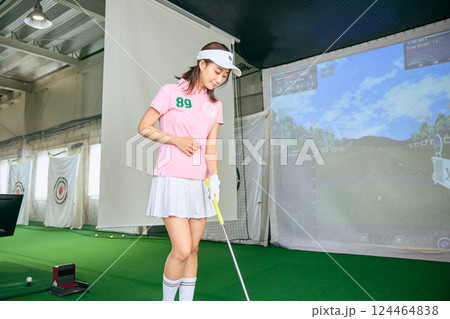 室内ゴルフ練習場で練習をする女性 室内ゴルフ練習場で練習をする女性 124464838