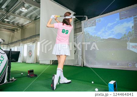 室内ゴルフ練習場で練習をする女性 室内ゴルフ練習場で練習をする女性 124464841