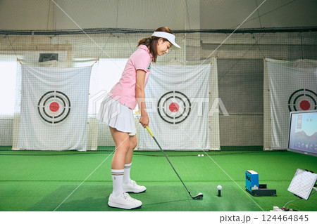 室内ゴルフ練習場で練習をする女性 室内ゴルフ練習場で練習をする女性 124464845