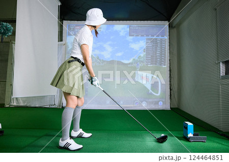 室内ゴルフ練習場で練習をする女性 124464851