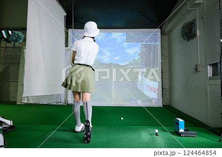 室内ゴルフ練習場で練習をする女性 124464854
