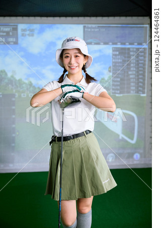 室内ゴルフ練習場で練習をする女性 124464861