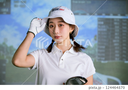 室内ゴルフ練習場で練習をする女性 124464870