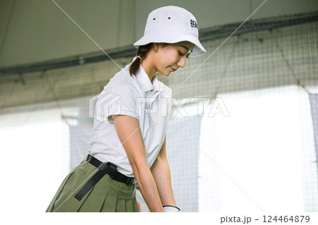 室内ゴルフ練習場で練習をする女性 124464879
