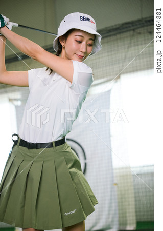 室内ゴルフ練習場で練習をする女性 124464881