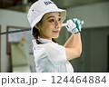 室内ゴルフ練習場で練習をする女性 124464884