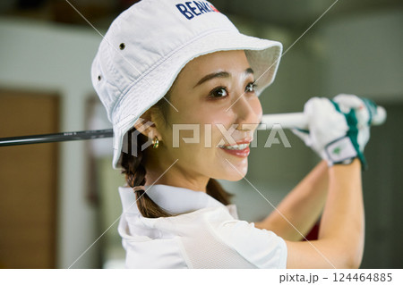室内ゴルフ練習場で練習をする女性 124464885