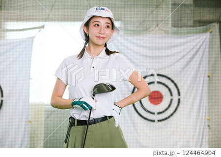 室内ゴルフ練習場で練習をする女性 124464904