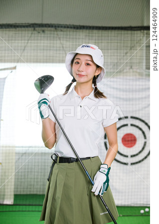 室内ゴルフ練習場で練習をする女性 124464909