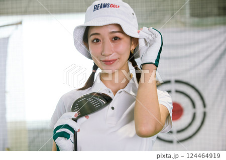室内ゴルフ練習場で練習をする女性 124464919