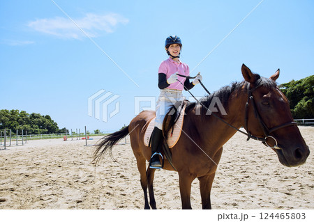 馬に乗って乗馬の練習をする女性 124465803