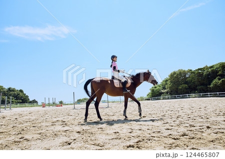 馬に乗って乗馬の練習をする女性 124465807