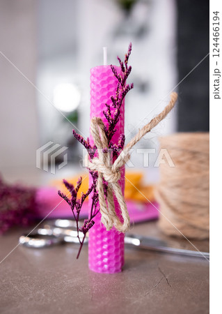Pink textured candle with dried flowers and twine on table Pink textured candle with dried flowers and twine on table 124466194
