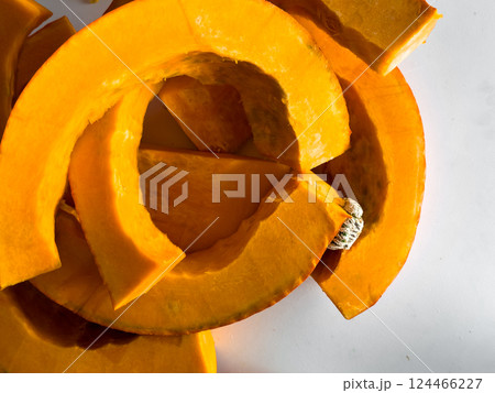 Fresh sliced pumpkin on white background with bright orange color and textured surface 124466227