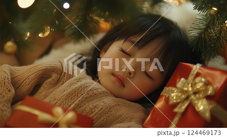 クリスマスツリーの下で眠る日本人の子どもと贈り物 124469173