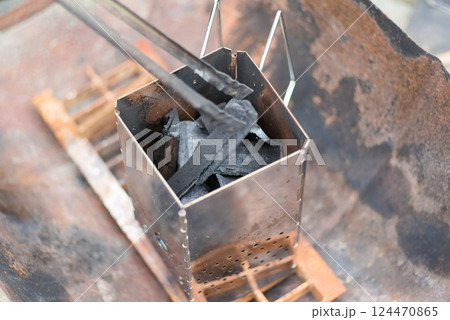 チャコールスタータで炭火を起こすキャンプシーン チャコールスタータで炭火を起こすキャンプシーン 124470865