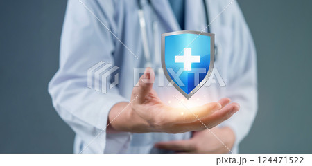 Medical shield floating above physician shows healthcare protection concept. doctor in white coat demonstrates glowing health insurance symbol. Bright medical cross icon on blue shield represents. Medical shield floating above physician shows healthcare protection concept. doctor in white coat demonstrates glowing health insurance symbol. Bright medical cross icon on blue shield represents. 124471522