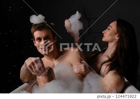 Couple sharing a moment together in bed while taking a selfie 124471922